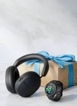 Sonos&nbsp;headphones&nbsp;and&nbsp;Garmin&nbsp;watch in front of&nbsp;wrapped&nbsp;gift box.
